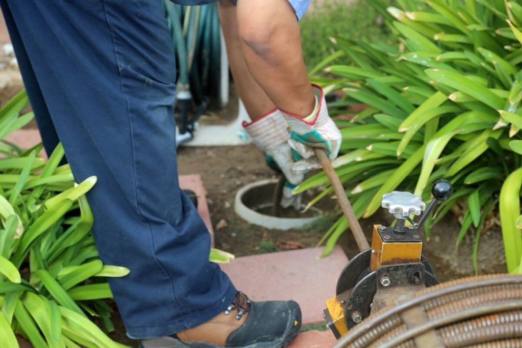 Plumber using electric eel to clear blocked sewer pipe/drain in Brisbane