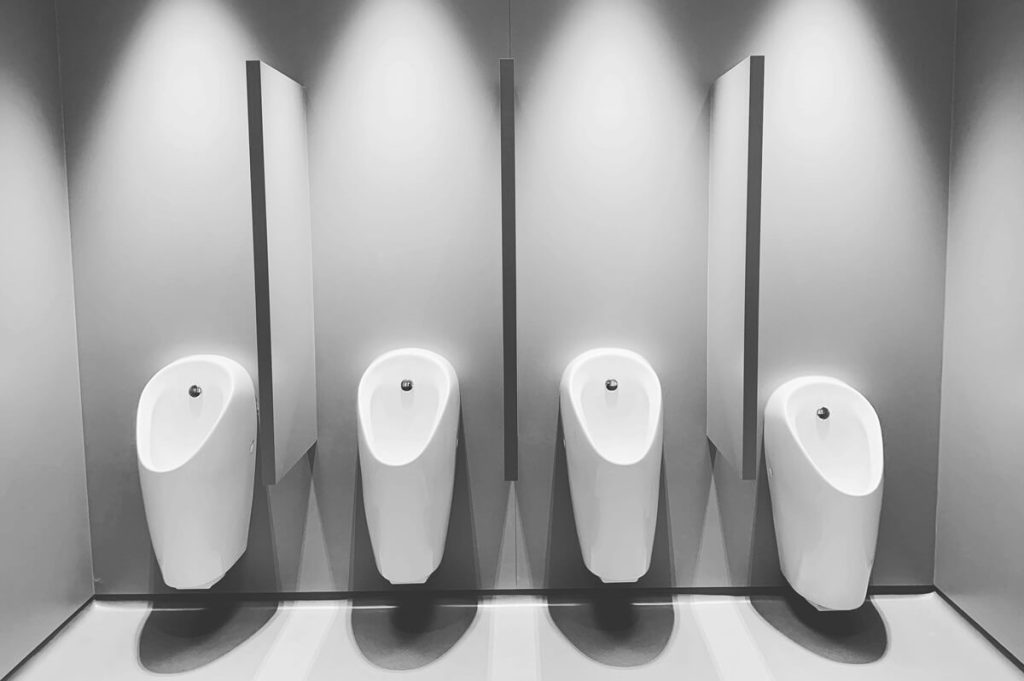 A bay of faulty urinals - call a commercial plumber for zip flushmaster urinal repairs and service
