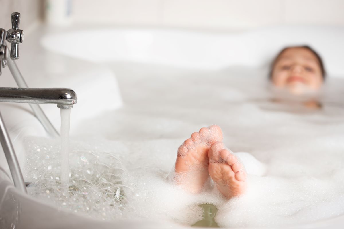 Child in bubble bath. Which is better for your home? Continous flow vs storage hot water?