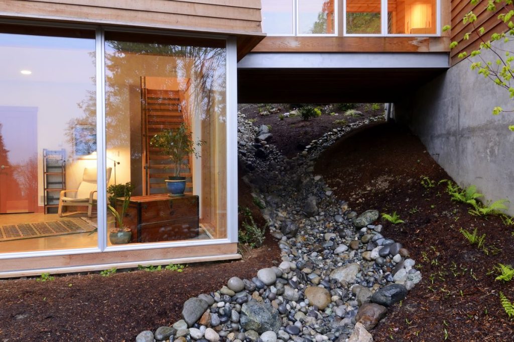 Swale, french and channel drains employed to keep water from foundations of house and deal with stormwater during wet season