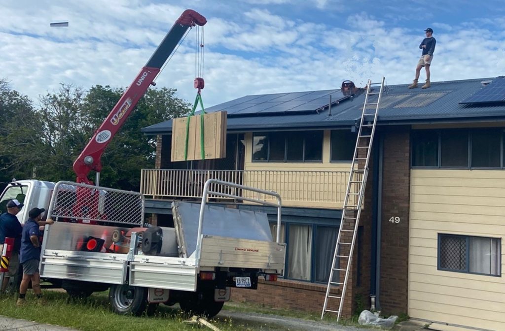 Plumber and crane truck hire for roof top solar hot water tank removal.