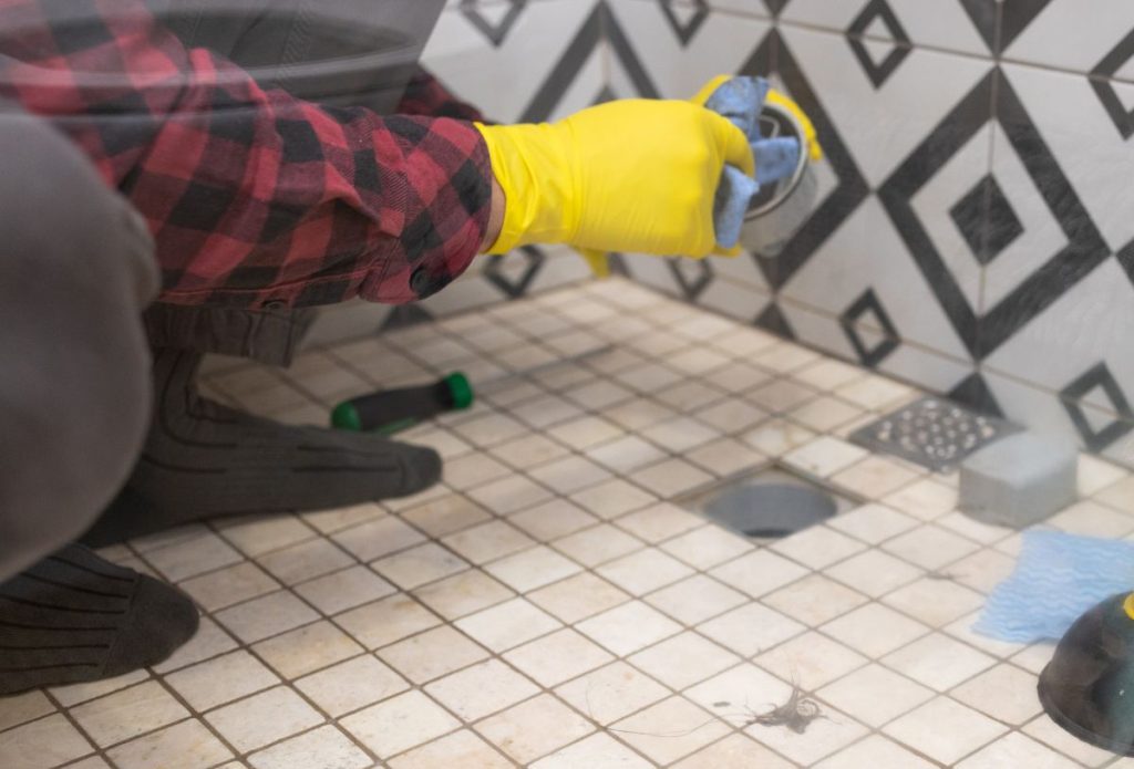 Cleaning up after unblocking a shower drain.