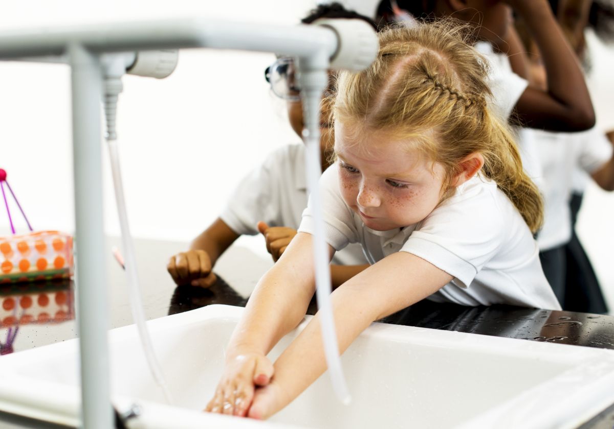 School children washing hands at sink installed by a school plumbing contractor
